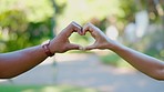 Heart, hands and couple outdoor for love, kindness or commitment to partner in park. Closeup of people, finger shape and care sign of support, trust and hope of icon, emoji or loyalty in relationship