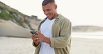 Happy man typing on phone, smile on beach and communication with wifi on holiday travel. Nature, outdoor and happiness, person writing message, email or social media meme on smartphone on vacation