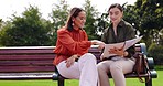 Business, professional and women on a bench, documents and discussion for freelance project, creative and share ideas. Female people, coworkers or ladies in a park, paperwork or notebook for planning