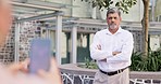 Photography, phone and arms crossed by senior man leader posing for photo outside of office building. Smartphone, photographer and mature male proud while pose for profile picture with thumbs up