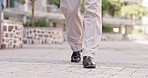 Business man, legs and walking in the city with shoes and travel for work on the ground. Businessman, outdoor traveling and person feet walk on a urban pavement ready for working in a town square