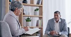 Senior woman, therapist and writing in meeting for counseling, problems or mental health at office. Elderly female psychologist talking and taking notes on businessman in therapy session at workplace