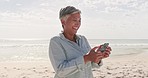 Beach, texting and happy elderly woman laughing at message, meme or joke outdoors. Smartphone, smile and indian lady online with funny app, text or browsing the internet while traveling in Bali