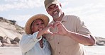 Senior couple portrait, heart and hand sign for love on the beach with happy marriage. Ocean, sea and smile of elderly people together with loving and kindness hands gesture in nature with happiness