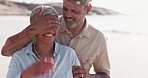 Man, woman and surprise at beach, cover eyes or happy on walk together in retirement, holiday or freedom. Senior couple, playful and romantic by ocean, sand or sunshine for outdoor vacation with love