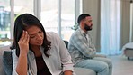 Upset, argument and angry couple on a sofa in the living room of their modern apartment or house. Divorce, breakup and young toxic man and woman with stress fighting or in disagreement in their home.