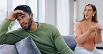 Couple, fight and ignoring on sofa in conflict, disagreement or argument in living room dispute at home. Upset or angry man and woman sitting arguing on couch in frustration for unhappy relationship