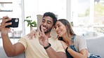 Selfie, couple kiss and peace sign in new home on sofa in living room, love and happiness. Interracial, smile and self picture of man and woman kissing, v hand gesture and moving into property.