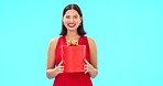 Excited woman, face and gift box in studio, happiness or think by blue background with smile. Girl, model and portrait with present package for birthday, valentines day or winning prize in promotion