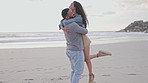 Hug, lifting and happy couple at a beach celebrating freedom, travel and romance. Smile, embrace and man with woman on vacation, holiday or trip, bond and fun while traveling in Florida together