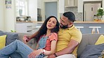 Couple, relax and talking on a sofa, happy and enjoying conversation, relationship and bond in their home. Love, embrace and man resting with woman on couch, smile and laughing, romantic and speaking