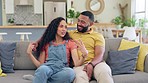 Happy, home and couple on a sofa, speaking and relax with happiness, romance and conversation. Partners, man and woman with joy, relationship and chilling on a couch, chatting and bonding with love  