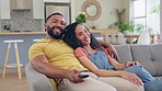 Happy couple, relax and watching tv on sofa for movie, entertainment or online streaming together at home. Man and woman relaxing to watch series or shows on living room couch in comfort indoors