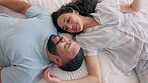 Happy couple, love and relax in a bed from above, smile and sharing romantic morning in their home. Resting, conversation and top view of man with woman in a bedroom waking up, talking and bonding