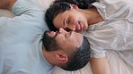 Love, and happy couple and face touching in bed from above, smile and romantic in their home. Relax, intimacy and top view of man with woman in a bedroom waking up, embracing and resting together 