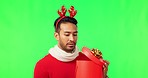 Disappointed, holiday present and green screen with a man opening a gift and feeling unhappy. Christmas fail, isolated and studio background with a Asian male model holding a box at a celebration