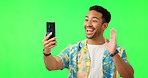 Hello, video call and man in green screen studio excited, smile and happy on mockup background. Hand, wave and asian guy travel influencer live streaming, content creation or blog to online followers