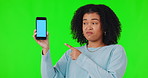 Woman, phone and bad review for mockup on green screen while pointing finger. African female person with a smartphone and negative emoji for website, advertising and app ux problem or poor service