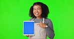 Happy, woman and pointing at tablet for advertising mockup, chroma key on studio green screen background. Portrait of female with mobile display for digital product, marketing or promotion mock up