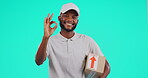 Portrait, delivery and emoji with a black man courier in studio on a blue background holding a box. Logistics, ecommerce and package with a happy male postal worker showing an okay hand gesture