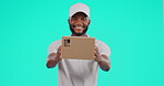 Portrait, delivery and service with a black man courier in studio on a blue background holding a box. Logistics, ecommerce and package with a happy male postal worker delivering a retail order