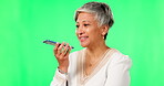 Cellphone, voice chat and woman on green screen in studio isolated on a background. Phone call, speech and senior female person in conversation, talking and discussion, speaking to contact and happy.
