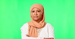 Muslim, portrait and woman in hijab with arms crossed, serious or angry face on green screen background. Senior, islamic lady and female person with frustrated or annoyed expression in studio
