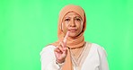 Face, green screen and Islamic woman with no, finger and disagreement against a studio background. Portrait, Muslim female person and model with review, hand gesture and frustrated with warning sign