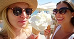 Two friends enjoying vanilla ice cream cones together on holiday