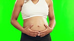 Hands, pregnant and stomach of a woman on a green screen with care, energy and love. Closeup of female person with baby belly exercise or bounce for pregnancy, health or wellness on studio background