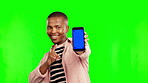 Happy black man, pointing and phone mockup on green screen for advertising against a studio background. Portrait of African male person showing mobile smartphone app with tracking markers on mock up