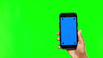 Person, hands and phone mockup on green screen for advertising against a studio background. Hand holding mobile smartphone app, display or chromakey with tracking markers for advertisement on mock up