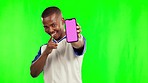 Black man, phone and mockup on green screen for advertising against a studio background. Portrait of African male person pointing with mobile smartphone app or tracking markers on mock up space