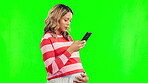 Pregnant, worried and a woman on a phone and green screen for internet research. Serious female person typing on smartphone for online pregnancy consultation or communication on a studio background