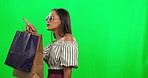 Fashion, shopping bags and woman in a studio with green screen after a style sale, promotion or discount. Sunglasses, luxury and young female model walking with stylish outfit by chromakey background