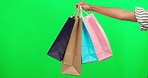 Shopping bag in hand, retail and green screen, product and boutique discount isolated on studio background. Customer with purchase, person buying and store sale with mockup space and commerce