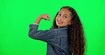 Strong, happy and a face of a girl on a green screen to show muscle, strength and motivation. Smile, portrait and a young child showing muscles and fitness results isolated on a studio background