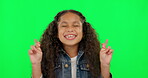 Hope, girl and excited with green screen and fingers crossed feeling happy with youth. Funny, smile and young child with good luck and emoji hand sign for crazy wish and kids dream of children