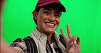 Happy woman, smile and peace sign for selfie on green screen against a studio background. Portrait of female person, traveler or tourist smiling for photo, vlog or online social media on mockup space