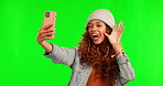 Happy woman, goofy face and selfie on green screen with silly facial expression against a studio background. Female person with smile and funny faces for memory, vlog or online social media on mockup