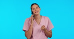 Talking doctor, happy and a woman on a phone call isolated on a blue background in a studio. Consulting, communication and a medical employee speaking on a mobile for nursing and medic advice