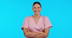 Face, nurse and woman with arms crossed, funny and happy lady on a blue studio background. Portrait, female person or medical professional with joy, humor or joke with a smile, healthcare or laughing