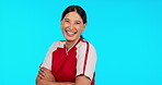 Soccer, smile and arms crossed with a sports woman in studio isolated on a blue background for training. Portrait, football and fitness with a happy young female athlete laughing or joking at humor