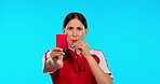 Referee, whistle and woman with a red card in studio isolated on a blue background mockup. Face, portrait and angry umpire giving penalty, warning or caution during soccer, football or sports game.