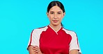 Serious, sport and face of a woman with arms crossed isolated on a blue background in a studio. Expert, fitness and portrait of a young girl for soccer or football training, sports motivation