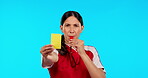 Referee, whistle and woman with a yellow card in studio isolated on blue background mockup. Face, portrait and angry umpire giving penalty, warning or caution during soccer, football or sports game.