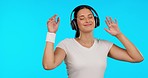 Music, headphones and woman dance in studio happy, free and streaming on blue background. Radio, earphones and female person dancing to podcast, audio or online subscription, track or playlist