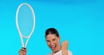 Face, tennis and woman cheering, winner and athlete with achievement on a blue studio background. Portrait, female person or player with a racket, champion or winning with fist, goals or celebration 