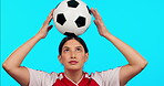 Sports, athlete and a woman with soccer ball on head for balance, exercise and training in studio. Happy female model person on a blue background for football game practice and fitness or motivation