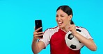 Woman, sports and video call in studio, talk and football celebration, excited and happy by blue background. Girl, professional soccer player and ball with webinar, communication or chat with success